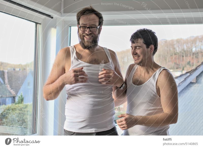 zwei junge männer in unterhemd, lachend Unterhemd Freunde Freundschaft Freude Zusammensein Glück positiv Spaß Feinripp heiter männliche Erwachsene schön