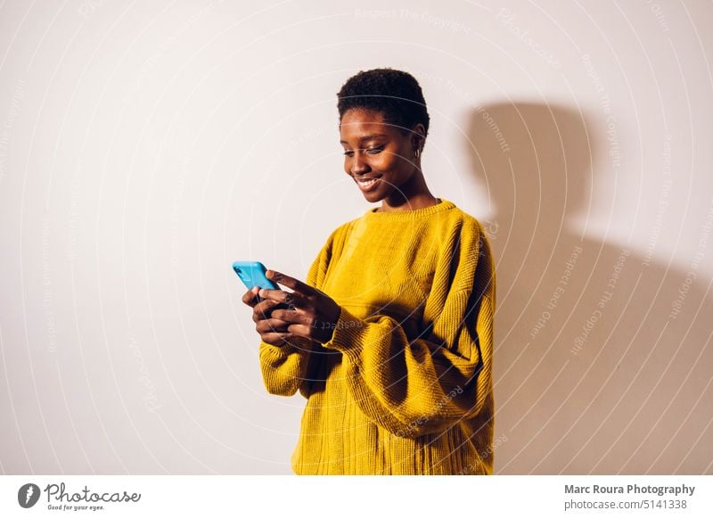 Frau textet auf Handy Erwachsener Afrikanisch Audio blanko Zelle Funktelefon plaudernd Mitteilung Kontakt Gerät digital Kopfhörer leer Mädchen Mädchen gehend