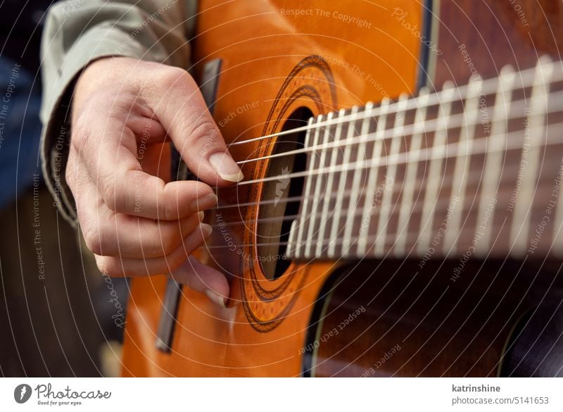 Männliche Hände spielen akustische Gitarre, Nahaufnahme.  Lehrer gibt Gitarrenunterricht Gitarrenspieler Fingerspitzen hölzern Waffen Zeichenketten