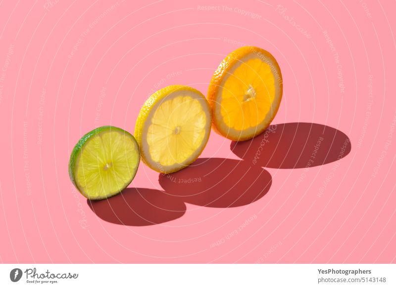 Zitrusfrüchte, einzelne Scheiben isoliert auf einem rosa Hintergrund. abstrakt ausgerichtet hell Farbe farbenfroh Konzept Textfreiraum kreativ Küche