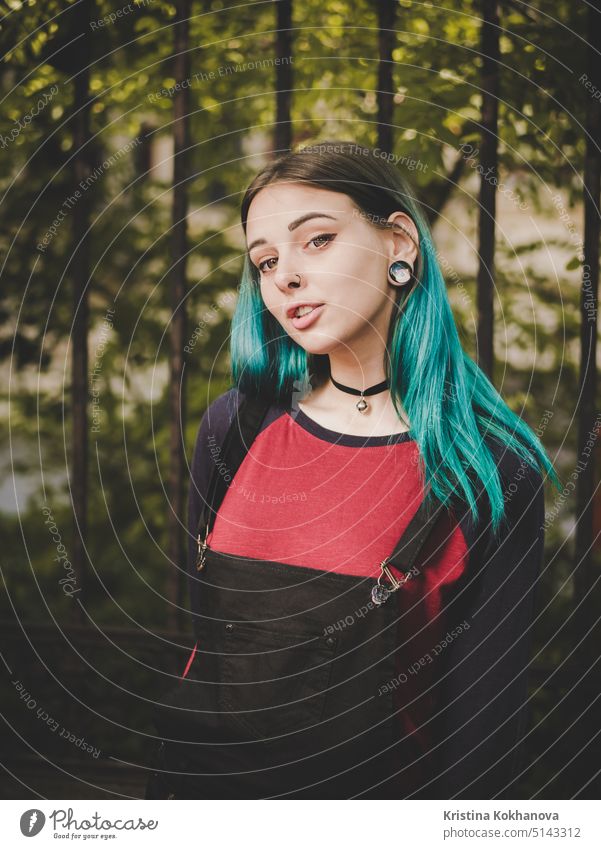Street Punk oder Hipster Mädchen genießt leere alte europäische Straße. Porträt von Teenager-Mädchen mit blau gefärbten Haaren, Piercing in der Nase, violette Linsen und ungewöhnliche Frisur.