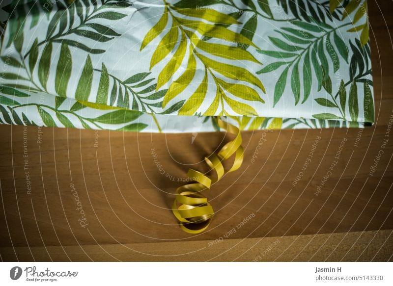 Geschenk- papier & band grün auf Holztisch Geschenkpapier Geschenkband Farbfoto Innenaufnahme Vorfreude Verpackung Überraschung Freude Menschenleer schenken