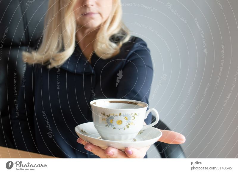 Frau hält eine Tasse Kaffee mit einer Untertasse. Selektiver Fokus auf die Tasse Erwachsener attraktiv schön Schönheit Getränk blond Café Koffein lässig
