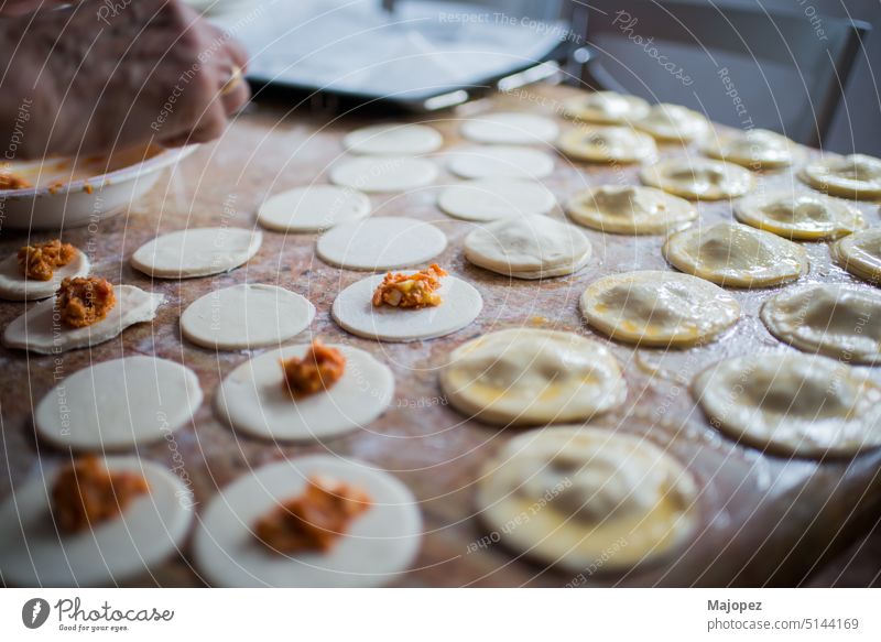 Füllen und Verschließen von Blätterteigknödeln in einer Küche Muster alte Frau Amuse-Gueule Hintergrund Schalen & Schüsseln Feier Nahaufnahme Essen zubereiten