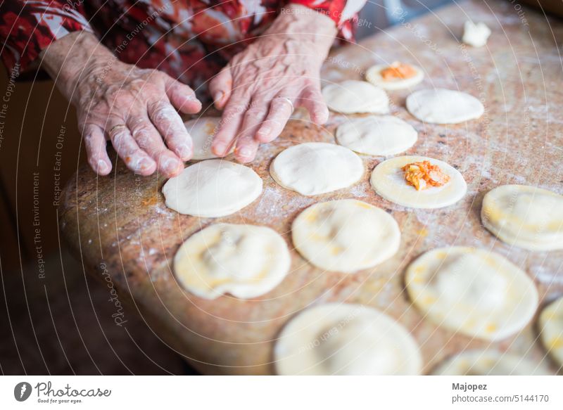 Menschliche Hände füllen und versiegeln Blätterteigknödel Muster alte Frau Amuse-Gueule Hintergrund Schalen & Schüsseln Feier Nahaufnahme Essen zubereiten