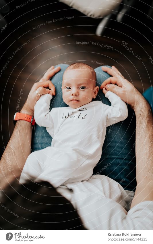 Porträt eines süßen Babyjungen, der auf den Knien seines Vaters liegt und zur Kamera schaut schön Junge Pflege Kaukasier heiter Kind Kindheit Komfort Inhalt