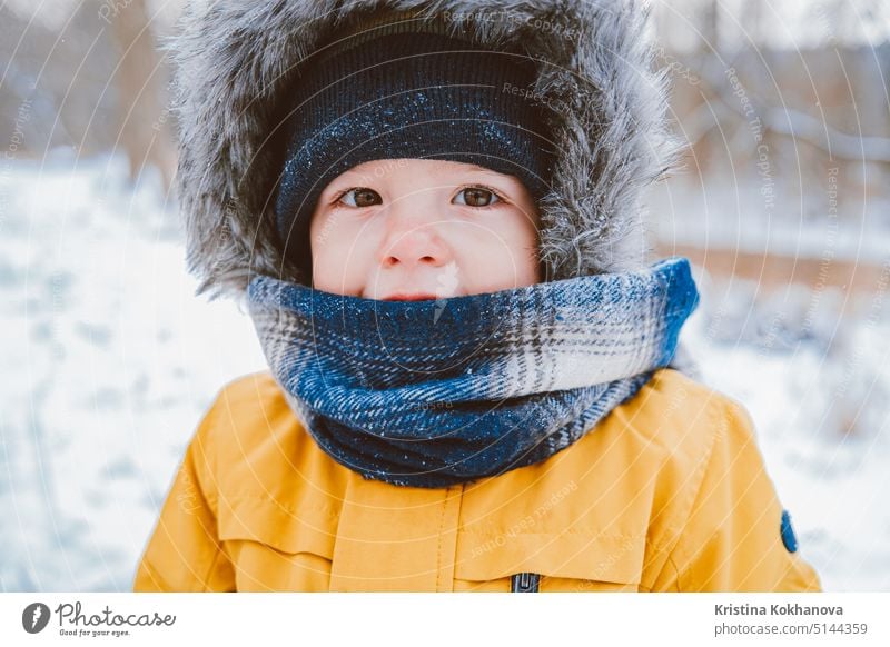 Nettes Porträt von kleinen Baby in Wintermütze auf verschneiten Wald Hintergrund. Sohn, Kleinkind Kind Konzept. Person Junge Kindheit Schnee Spaß Freude Familie