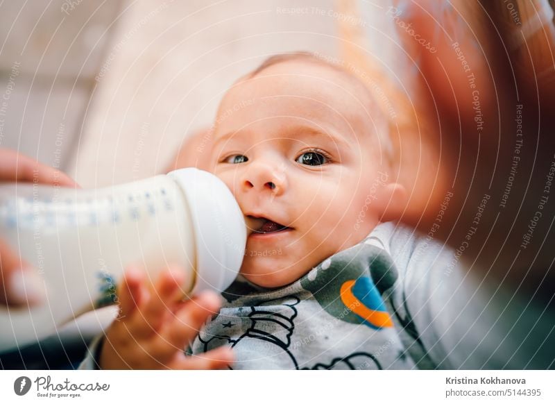 Kleiner Babyjunge trinkt Muttermilch aus der Flasche und lächelt Junge Pflege Kaukasier Kind Kindheit niedlich Lebensmittel Säugling wenig melken bezaubernd