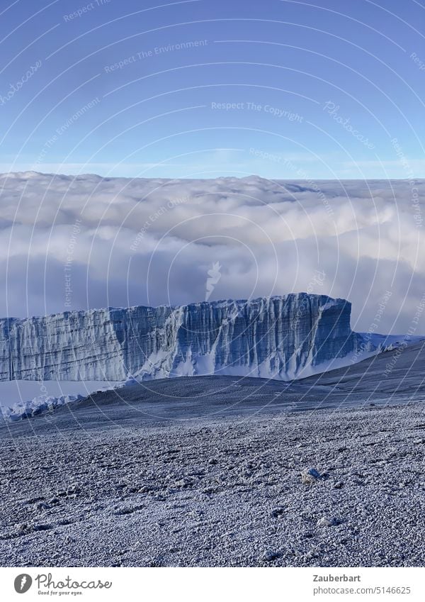Blick auf Gletscher des südlichen Eisfelds vom Kraterrand des Kilimanjaro, dahinter Wolkendecke Geröll Himmel Höhe Kibo Uhuru Peak Wandern Abenteuer Berge