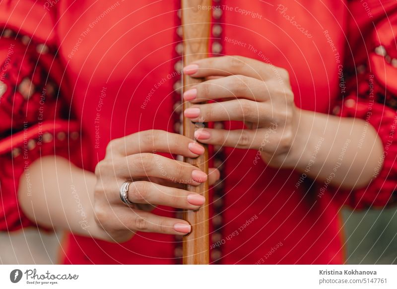 Frau spielt Holzblasinstrument Holzflöte - ukrainische Sopilka im Freien. Volksmusik-Konzept. Musikinstrument. Lady in traditionellen gestickten Hemd - rot Vyshyvanka.