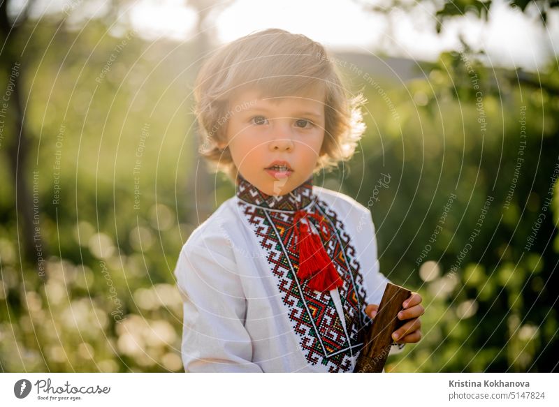 Porträt des kleinen Jungen mit Holzblasinstrumenten Holzflöte - ukrainische Sopilka. Konzept der Volksmusik. Musikinstrument. Kind in traditionellen gestickten Hemd - Vyshyvanka.