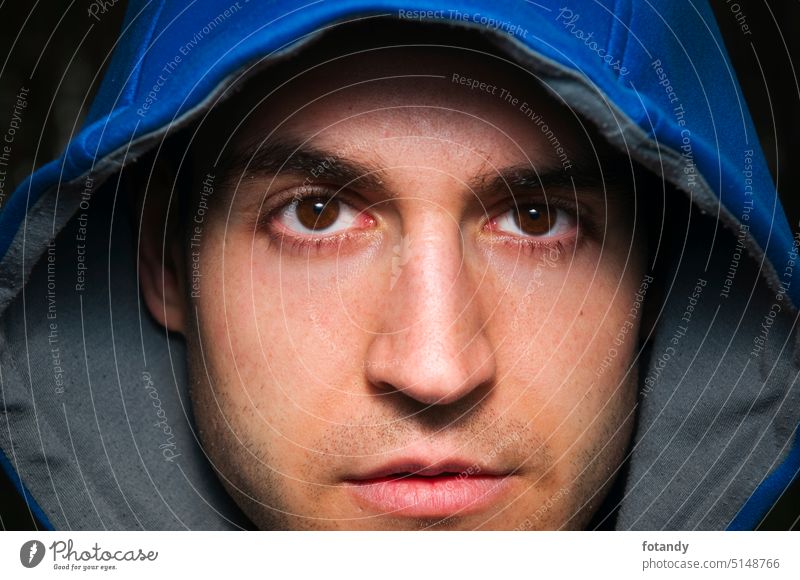 Gesicht eines Mannes mit blauer Kapuze Dschungel Kapuzze Gesichtsporträt Blick in die Kamera abschließen Detailaufnahme Gesichtsausdruck Kopfbedeckung