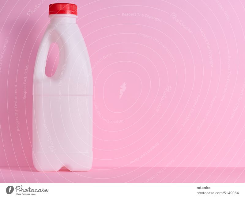 Weiße Plastikflasche für Milch und Molkereiprodukte auf einem rosa Hintergrund melken Flasche Kunststoff weiß Produkt trinken liquide Container Kannen Gallone
