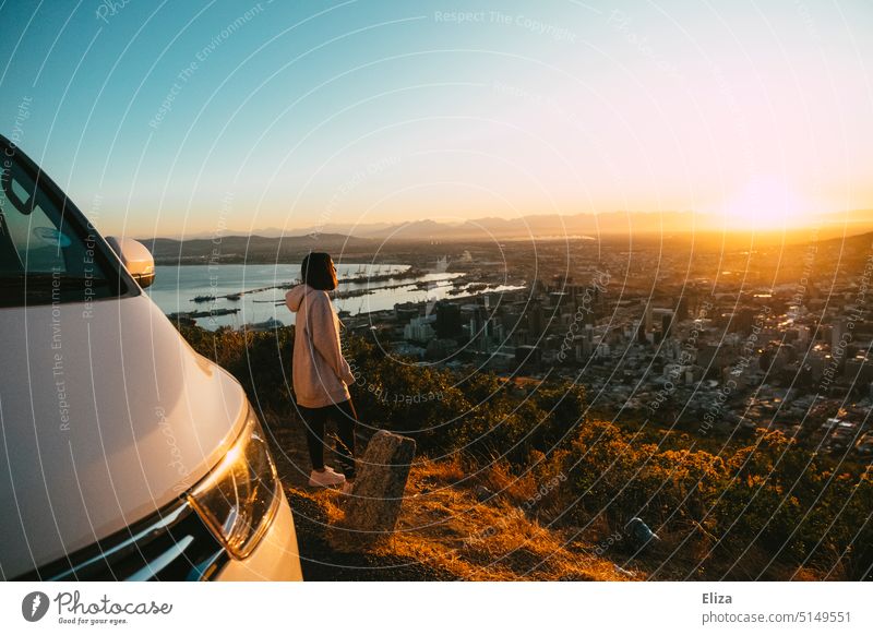 Frau steht auf einem Aussichtspunkt und betrachtet den Sonnenaufgang über Kapstadt Reisen Abenteuer Van Ferien & Urlaub & Reisen Freiheit Ausflug Stadt Ferne