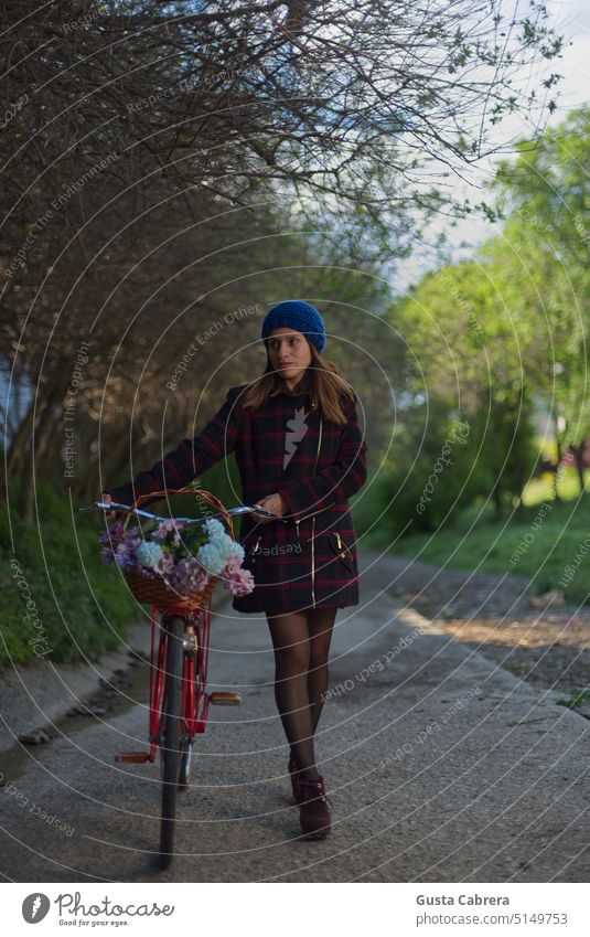 Mädchen und ihre Gedanken, sie fährt auf ihrem roten Fahrrad mit Blumen. Frau Junge Frau Jugendliche Farbfoto Rotes Fahrrad Außenaufnahme