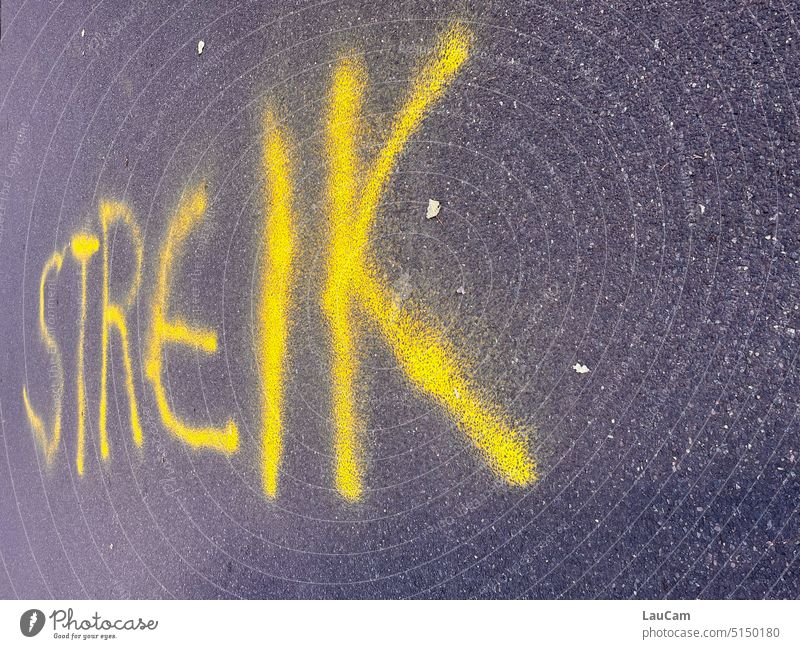 Streik streiken Graffiti Schrift Aufruf zum Streik Ankündigung Warnung Warnhinweis Buchstaben Asphalt Straße gelb grau Schriftzeichen Typographie Text Wort