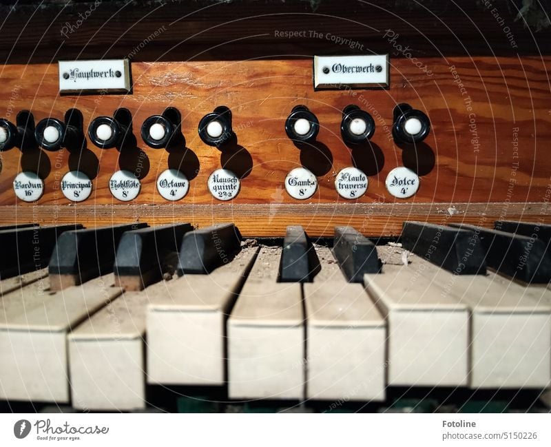 Detailaufnahme einer alten Orgel. Auf den Tasten liegt Staub und Dreck. Hier wurde lange nicht mehr in die Tasten gehauen. Musikinstrument musizieren