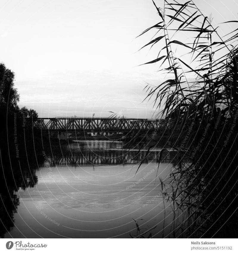 Schwarz-Weiß-Landschaft von Fluss und Eisenbahnbrücke über sie Architektur schwarz Brücke Brückenspiegelung Küste verbinden Konstruktion durchkreuzen See Licht
