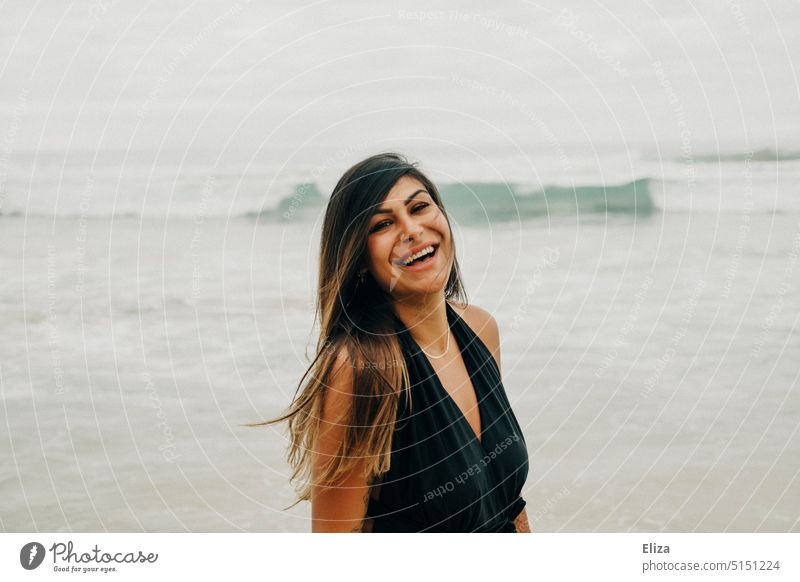 Lachende Frau in schwarzem Badeanzug am Strand strand lachen Freude gute laune ausgelassen Fröhlichkeit Lebensfreude Meer positiv Mensch feminin Junge Frau