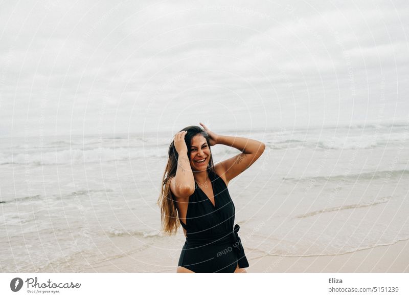 Lachende Frau in schwarzem Badeanzug am Strand strand lachen Freude gute laune ausgelassen Fröhlichkeit Lebensfreude Meer positiv Mensch feminin Junge Frau
