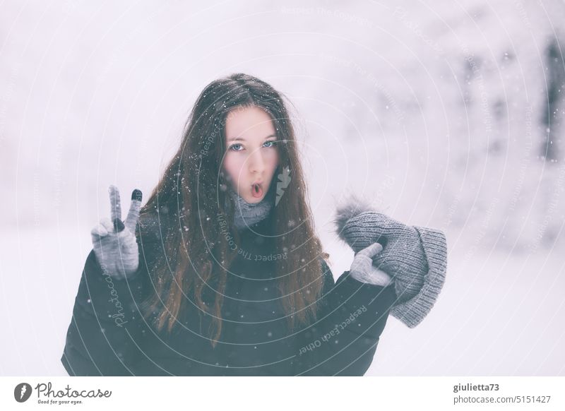 Winter-Porträt einer coolen Teenagerin, die das Victory-Zeichen/ Siegeszeichen zeigt Mädchen Junge Frau Jugendliche Pubertät verrückt Fisch Coolness weiß Schnee