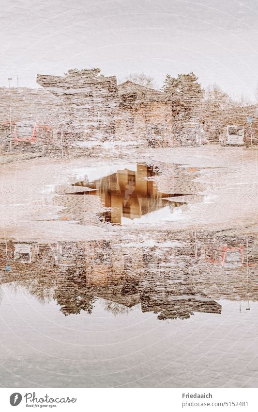 Gebäudespiegelung in einer Pfütze als Doppelbelichtung Spiegelung im Wasser Pfützenspiegelung Außenaufnahme Reflexion & Spiegelung Bahnhofsgelände nass Farbfoto