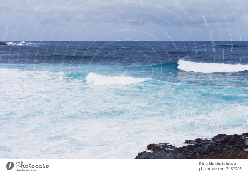 Landschaft mit Blick auf den Ozean mit starken Wellen. Blaue Farbpalette. Surfing Spot mit großen Wellen. Wetterbedingungen und Klimawandel. Urlaub am Strand horizontale Kulisse.