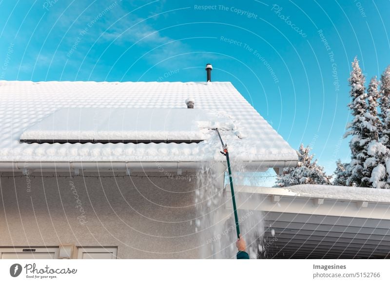 Schneeschieben auf dem Dach. Schnee von Solaranlage - Balkonkraftwerk im Winter entfernen. Solaanlage Sonnenkollektoren Photovoltaikanlage Solarzellen bedeckt