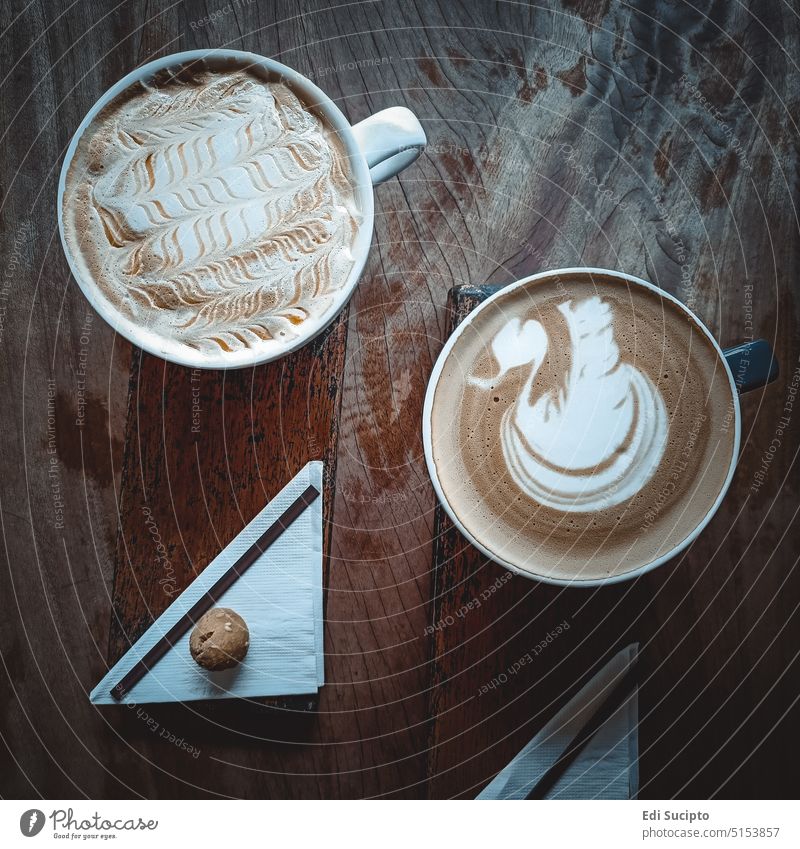 Zwei Tassen Kaffee auf einem Holztisch Aroma Kunst braun Café Koffein Cappuccino trinken Espresso schäumen heiß Latte melken Becher Tisch hölzern