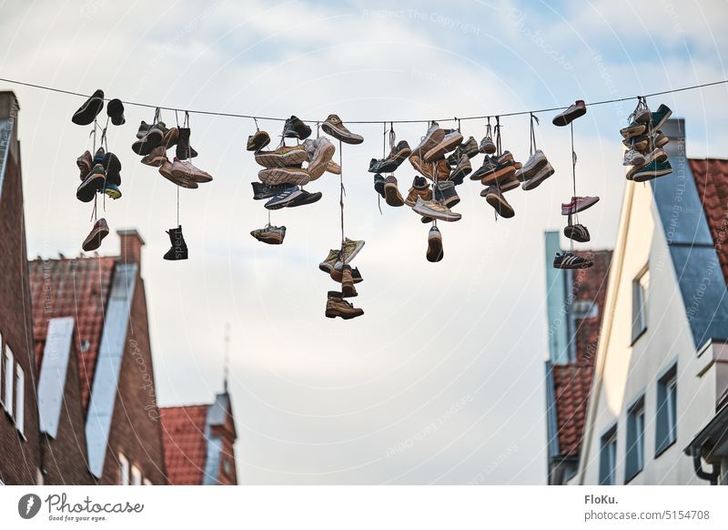 Schuhe hängen an einer Leine Stadt Fassade Dächer Luft Höhe Schnur Schuhpaar Farbfoto Außenaufnahme Tag alt Architektur Altstadt Gebäude Recycling Stadtzentrum