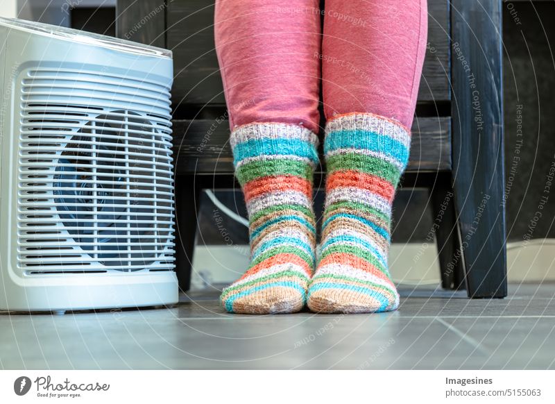 Heizperiode. Füße in Socken. Raum heizen mit Heizlüfter  Elektroheizung zu Hause. Saison Erwachsener Gerät Kleidung Erkältung und Grippe kalte Temperatur Farbe