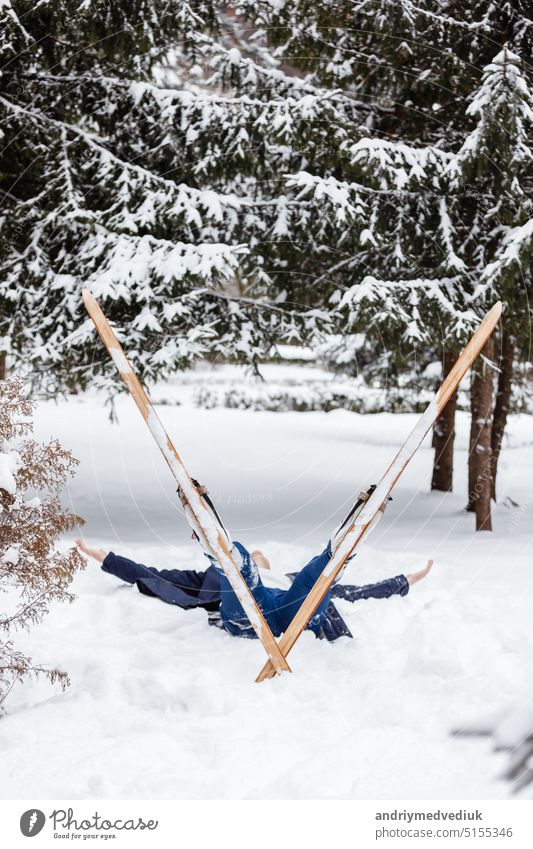 Schöne kalte Waldblick und Skifahrer tragen in Skiern, die liegen und entspannen nach dem Skifahren. Wintertag auf einer Piste, Piste, Skifahrer auf der Strecke im Winter, Prozess der Skilanglauf in den Wäldern