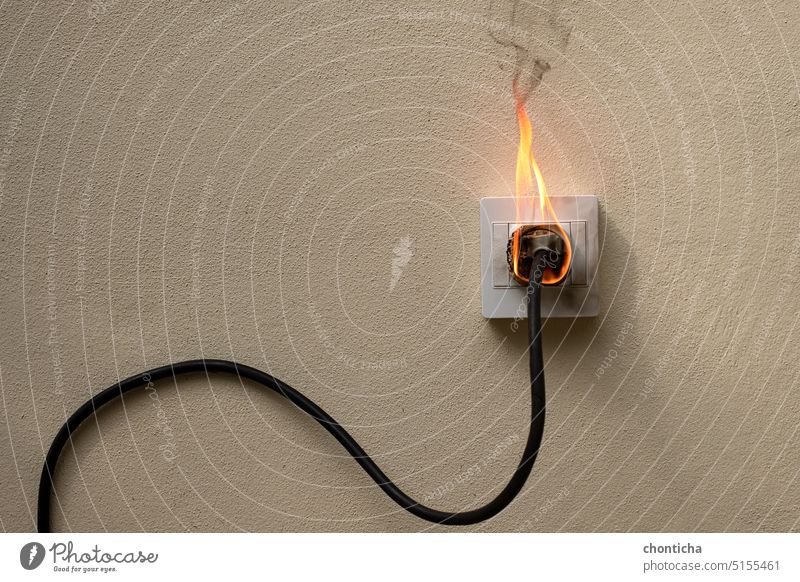 Auf Feuer elektrische Draht Stecker Steckdose auf der Betonwand Sichtbeton Hintergrund mit Kopie Raum Flamme Verkaufsstelle Wand rallonge Schock Kraft Kabel