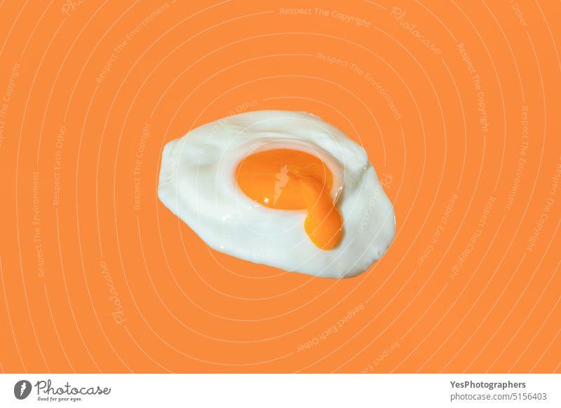Spiegelei minimalistisch auf einem orangefarbenen Hintergrund mit tropfendem Eigelb abstrakt Frühstück hell Nahaufnahme Farbe Konzept Essen zubereiten