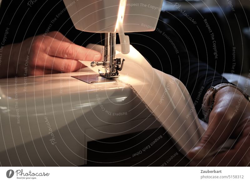 Die Näherin II - Hände halten Stoff unter den Nähfuss einer Nähmaschine, warmes Licht Nähen Handarbeit Nähfuß-Senkhebel Nadel Handwerk Schneidern Detailaufnahme