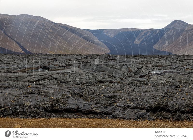 frisches Lavafeld , im Hintergrund der Vulkan Fagradalsfjall in Südisland erstarrt Vulkanismus Island Geologie Urgestein fließend schwarz Schwefel Geruch heiß