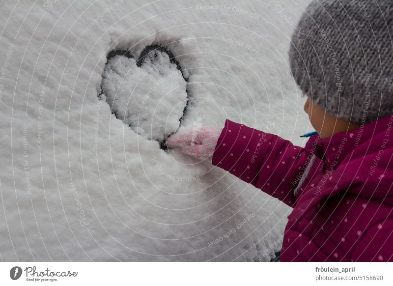 Schneeherz | Kind malt mit dem Finger ein Herz in den Schnee Winter Winterstimmung Schneedecke kalt Wintertag weiß winterlich Kälte Winterkleidung Handschuhe