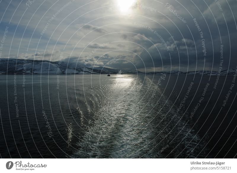 Heckwasser im Gegenlicht an winterlicher Küste von Norwegen und einem kleinen Boot winterliche Sonne Winterstimmung schiffsreise kalt Kälte winterliche Kälte