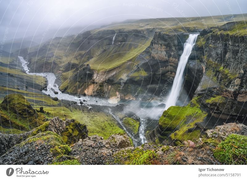 Hochland von Island. Der Wasserfall Haifoss und der Fluss Fossa fließen durch das Tal. Die Hügel und Klippen sind mit grünem Moos bedeckt Landschaft haifoss