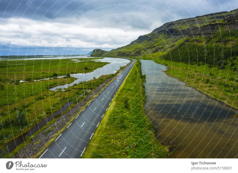 Island. Blick aus der Luft auf Berg, Feld und Fluss. Landschaft in Island in der Tageszeit. Blick von einer Drohne. Sommer. Bewölktes Wetter. Frisches Gras auf einem Feld. Reisen und Urlaub Bild