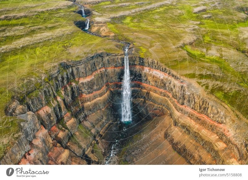 Luftaufnahme des Hengifoss-Wasserfalls in Ostisland. Der Hengifoss ist der dritthöchste Wasserfall in Island und ist von Basaltschichten mit roten Tonschichten zwischen den Basaltschichten umgeben