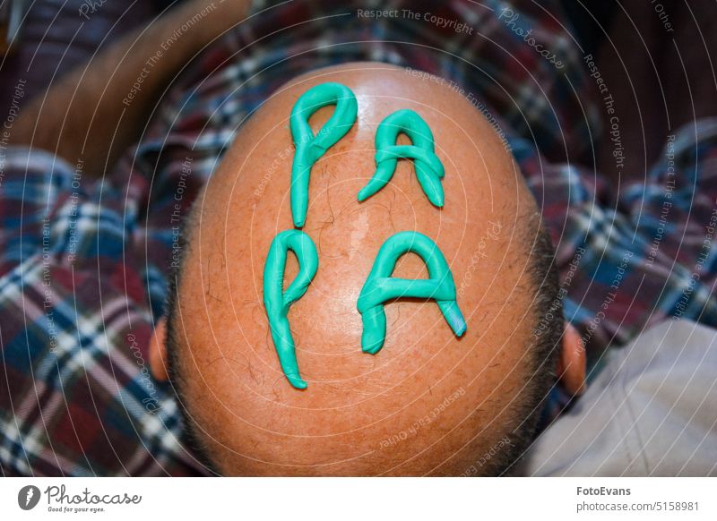 Das Wort PAPA auf dem Kopf eines kahlen Mannes geformt Papa schreibend von oben lustig. Lustig Knetmasse menschlich haarlos Lifestyle Haut Haarausfall wirklich