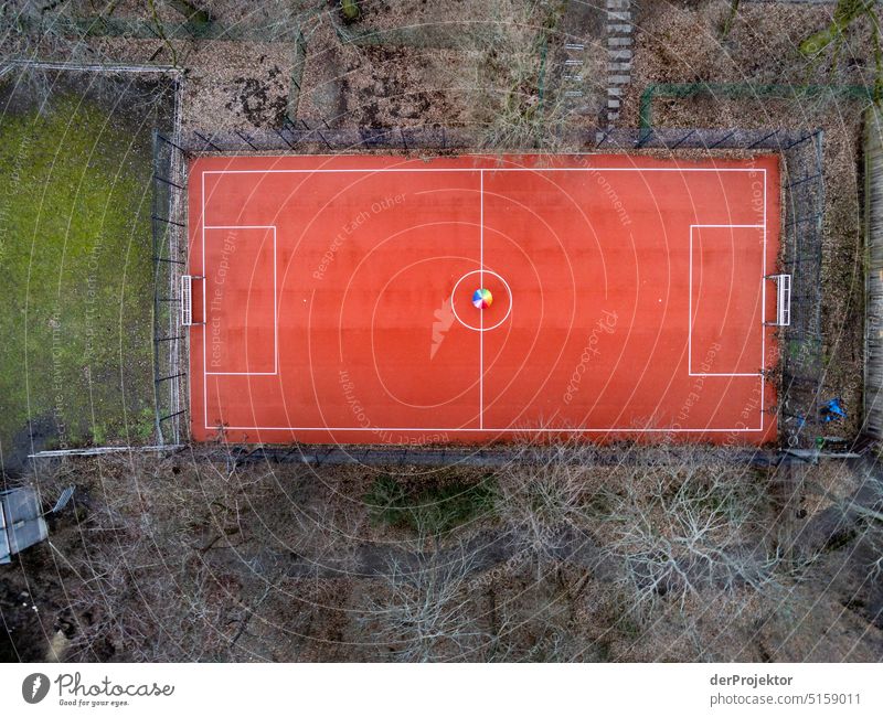 Luftbild eines kleinen Fußballplatzes mit regenbogenfarbigen Regenschirm Sport Luftaufnahme Menschenleer Textfreiraum Mitte Strukturen & Formen