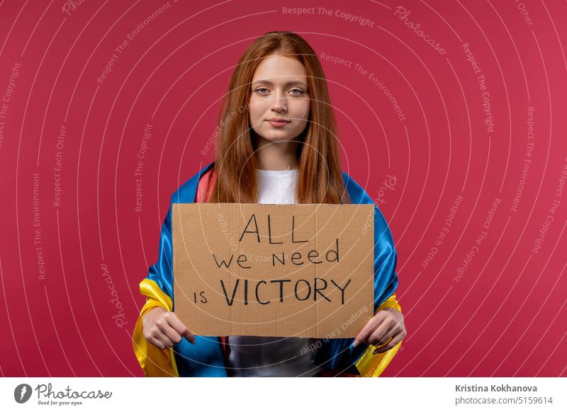 Ukrainische Frau mit Karton All we need is victory auf rosa Hintergrund. Ukraine gewinnen Krieg. Demokratie, Freiheit, Demonstration, russisches Aggressionskonzept