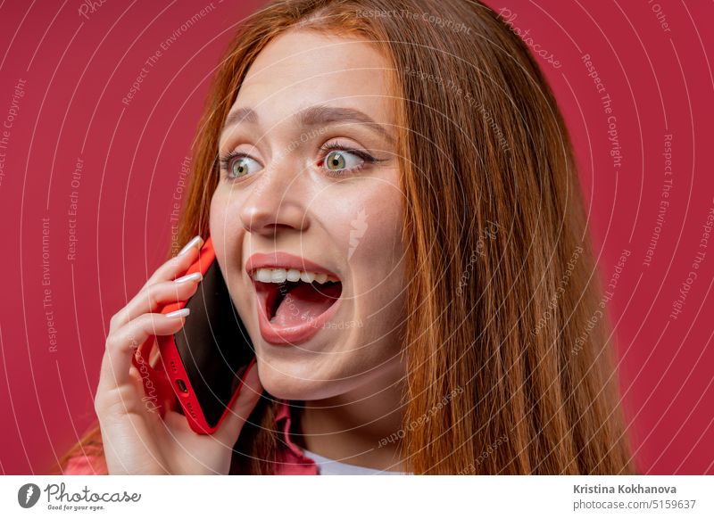 Überrascht Frau spricht am Telefon, tolle Neuigkeiten, offener Mund, wow. Junge Frau auf rosa Hintergrund. Mit Smartphone anrufen. schöne Antwort