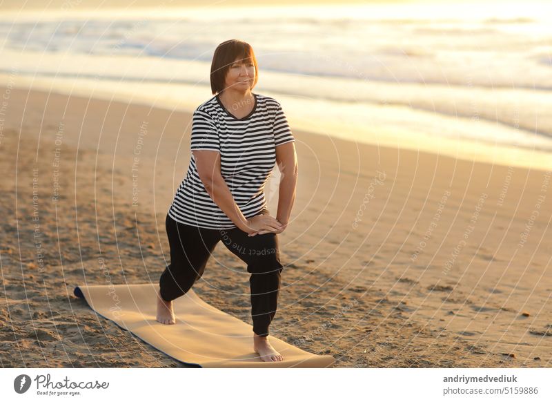gesunde Yoga Mittelalter Frau Workout Yoga-Pose auf der Matte am Sandstrand bei Sonnenaufgang, Vorteile der natürlichen Umgebungen für körperliche, geistige, gesunde, entspannende Konzept