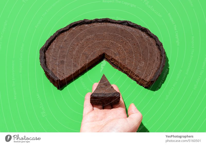 Schokoladenkuchen isoliert auf grünem Hintergrund. Ein Stückchen Kuchen nehmen gebacken schwarz hell braun Business Kalorien Tabelle Kakao Farbe Konzept