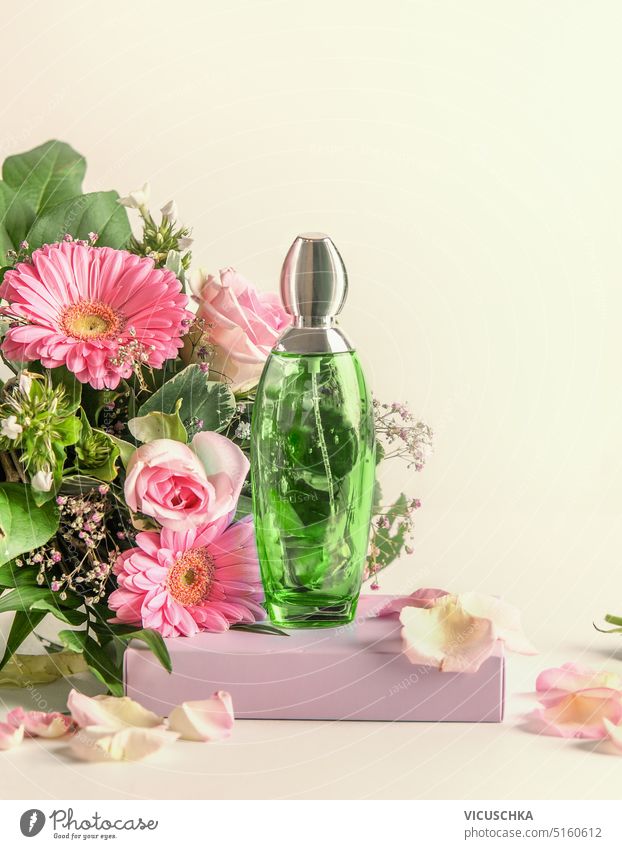 Grüne Parfümflasche auf Podest mit Blumenstrauß, Vorderansicht. Natürlicher blumiger Duft grün Parfumflakon Podium Haufen natürlich geblümt Wittern elegant
