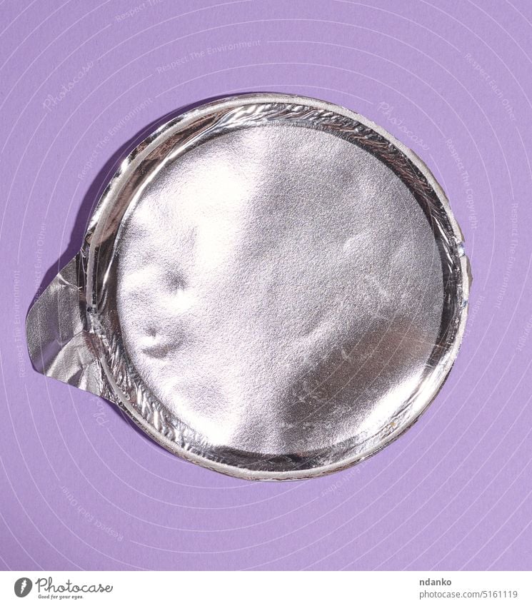 Aluminium runder Deckel aus unter dem Paket mit Chips auf einem lila Hintergrund, flach legen purpur grau industriell Küche niemand Schot glänzend Silber