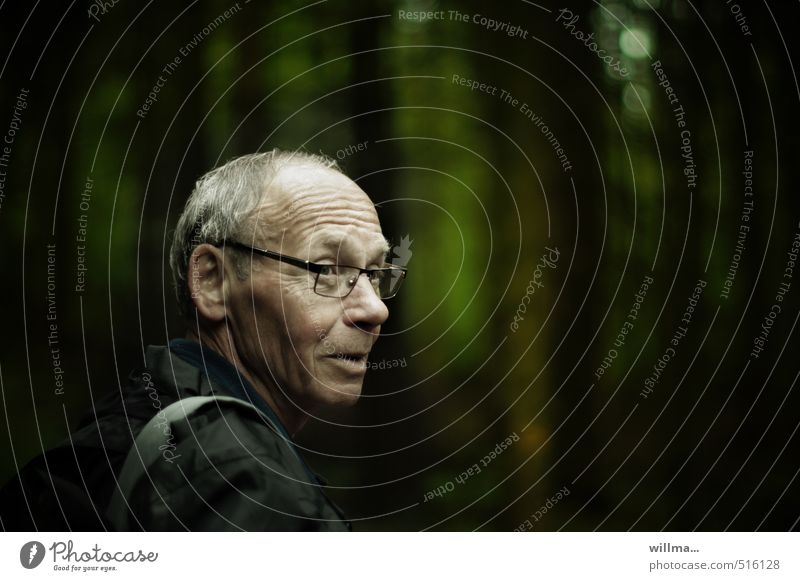 Porträt eines älteren Mannes im Wald Lebensabend Männlicher Senior Großvater Kopf Hautfalten Mensch Brille grauhaarig dunkel Freundlichkeit bescheiden Lächeln